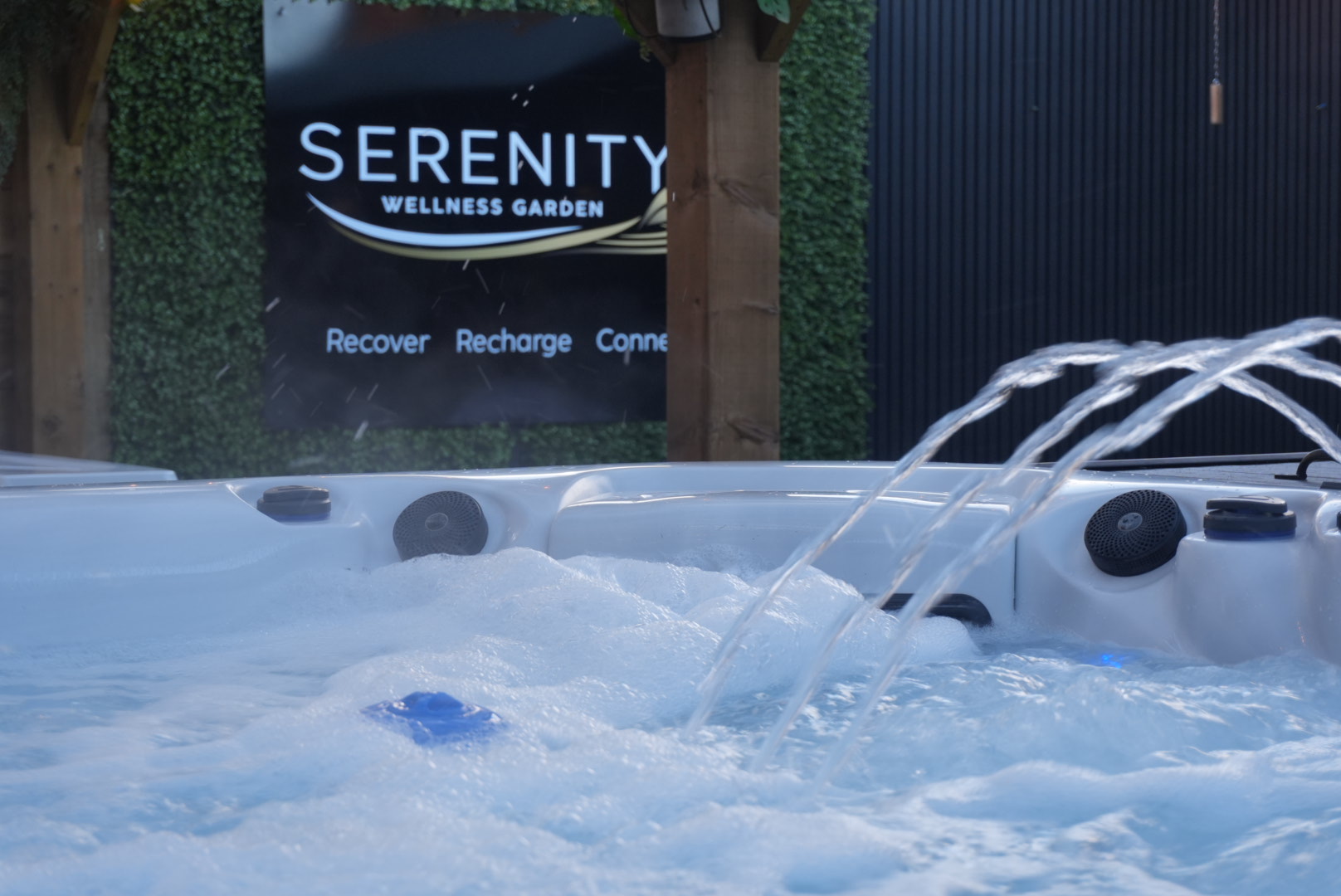 Hot tub in front of the Serenity Wellness Garden sign